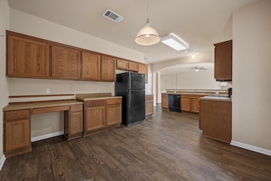 Kitchen with black appliances, brown cabinets, da