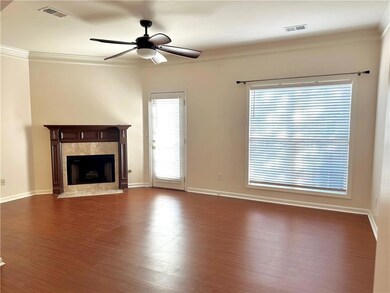 Unfurnished living room with a ceiling fan, dark wood-style floors, ornamental molding, a premium fireplace, and baseboards