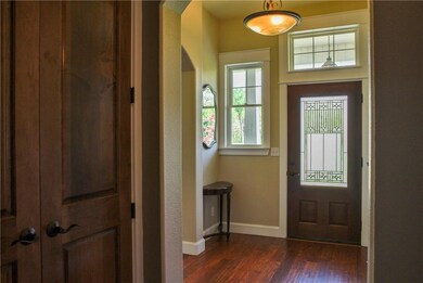 Entry foyer features arched doorways, rich engineered wood floors, and a beautifu new front door.