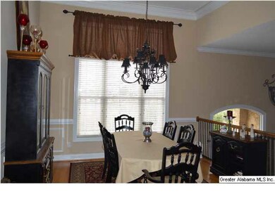 Separate dining room is beautifully decorated with wrought iron lighting & stair railing for a gorgeous open atmosphere