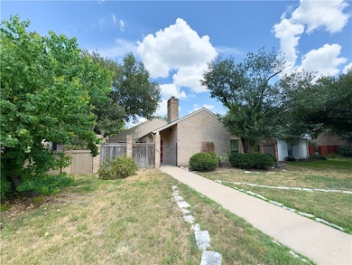 View of front of property featuring a chimney and brick siding