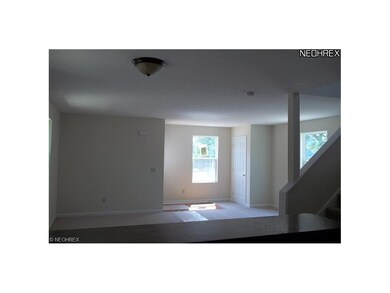 living room off kitchen and open staircase