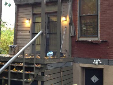 Exterior Back. Entrance for Unit 1 and Basement. L