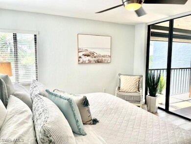 Bedroom featuring access to outside, wood finished floors, a ceiling fan, and a wall of windows