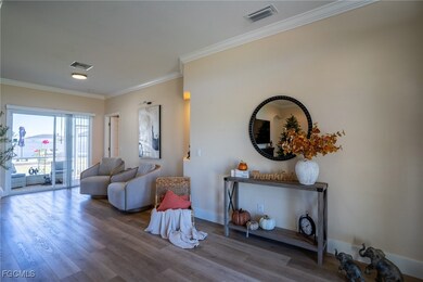 Living area with ornamental molding and wood finished floors