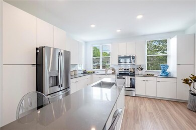 Kitchen featuring appliances with stainless steel finishes, white cabinets, and light hardwood / wood-style floors