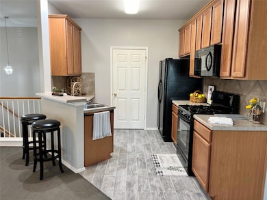 Kitchen with a peninsula, brown cabinets, a kitch