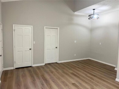 Empty room with crown molding, wood finished floors, and a textured ceiling
