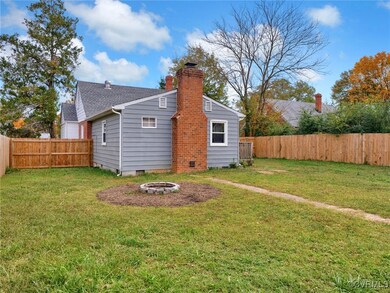 Back of house featuring a fenced in lawn & fire pi