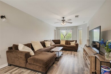 Living room with baseboards, a ceiling fan, visibl