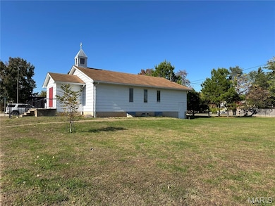 View of property exterior featuring a lawn