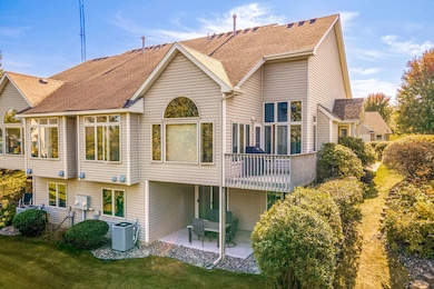 Striking back view with expansive windows, private deck, and covered patio for year-round enjoyment.