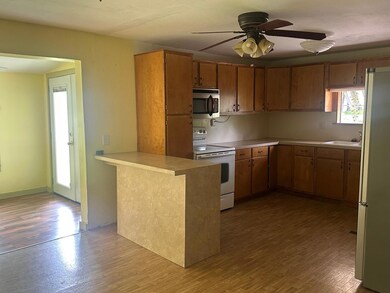 Kitchen featuring brown cabinetry, white electric 