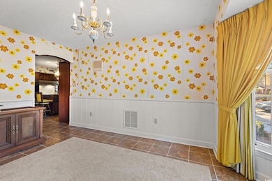 Spare room with a chandelier, a textured ceiling, 