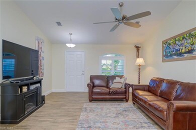 Living room with vaulted ceiling, ceiling fan, and