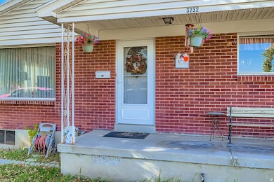 Entrance to property with a porch and brick siding