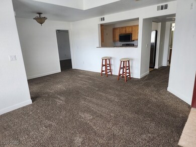 Carpeted living area featuring baseboards
