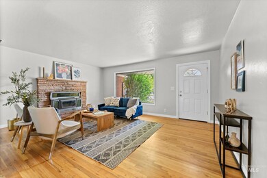 Living room with light wood-type flooring, a fireplace, and a textured ceiling