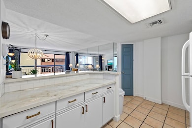 Kitchen featuring white cabinets, hanging light fi
