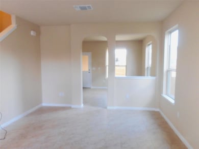 Empty room featuring arched walkways and baseboar