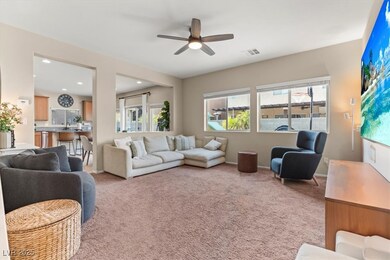 Living room featuring a ceiling fan, light carpet,