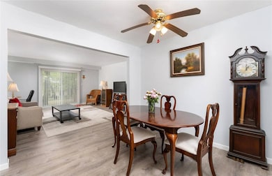 Dining room with light wood-style flooring, ceiling fan, and baseboards
