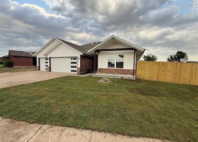 View of front of home with board and batten siding, an attached garage, driveway, and brick siding
