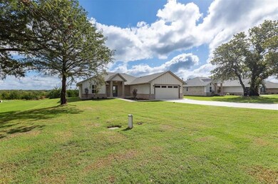 Single story home with a garage and a front yard