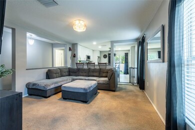 Spacious great room open to the kitchen with barstools at the kitchen island.