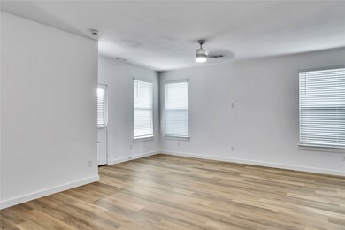 Empty room with baseboards, a ceiling fan, visible vents, and light wood-style floors