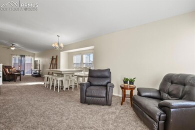 Carpeted living room featuring ceiling fan with no