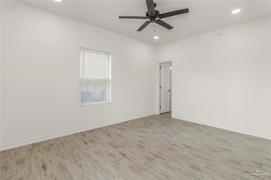 Spare room featuring light wood-style flooring, recessed lighting, a ceiling fan, and baseboards