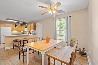 Dining room with light wood-type flooring, a textured ceiling, and ceiling fan
