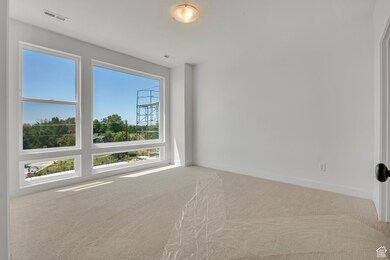 Carpeted spare room featuring baseboards