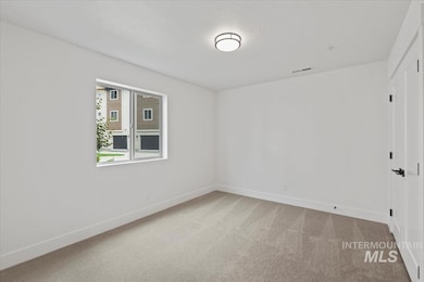 Spare room with light carpet and baseboards