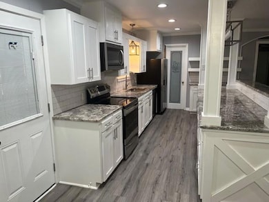 Kitchen with decorative backsplash, white cabinets