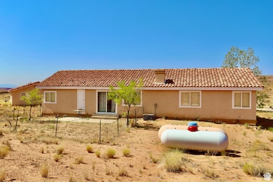 Back of property with a tile roof and stucco siding