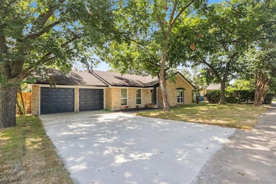 View of front of house with a garage, concrete driveway, brick siding, and a front lawn