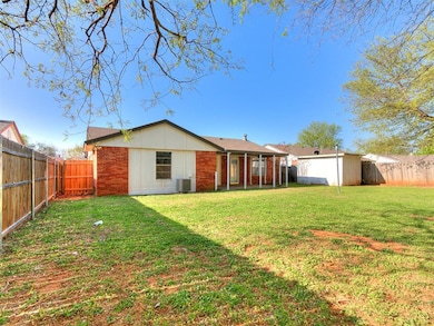 Back of house with a fenced backyard, board and ba