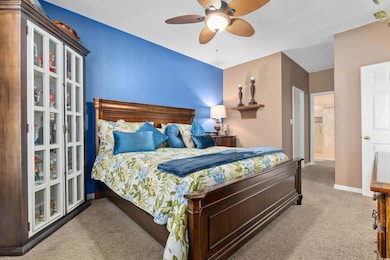 Carpeted bedroom with baseboards and ceiling fan