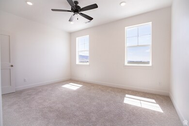 Spacious primary bedroom with ceiling fan and 9' high ceiling