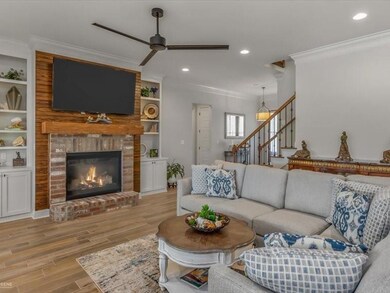 Living room featuring crown molding, a fireplace, 