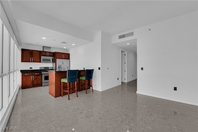 Kitchen featuring a breakfast bar, dark countertops, recessed lighting, appliances with stainless steel finishes, and open floor plan