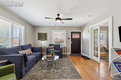Living room with view of French doors leading into a bedroom being used as a den