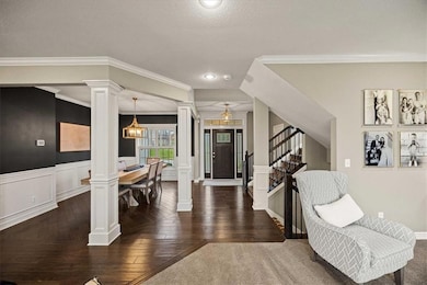 Foyer with ornamental molding, stairs, a textured ceiling, dark wood-type flooring, and recessed lighting