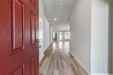 Corridor featuring light wood-type flooring and recessed lighting