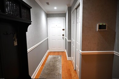 Front entrance with crown molding and chair rail and double door closet