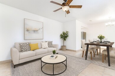 Dining area with tile flooring, neutral walls, and natural light — beautifully arranged with a modern table set, wall décor, and area rug for a welcoming touch. Virtually Staged