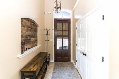 Foyer entrance with baseboards and a chandelier