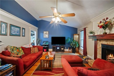 Living room featuring vaulted ceiling, ceiling fan